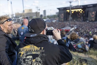 Copenhagen, Denmark - 19 June 2024: Festivalgoers in front of the logo at the Copenhell Metal