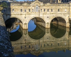 Pulteney Bridge reflected in water of River Avon, Bath, Somerset, England, UK