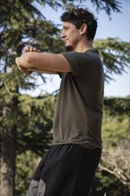 Vertical shot of a mature man practicing Kung Fu, Chinese martial arts, in a natural setting