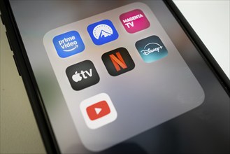 Streaming app icons on smartphone screen, including Netflix, AppleTV, Prime Video, Magenta TV,