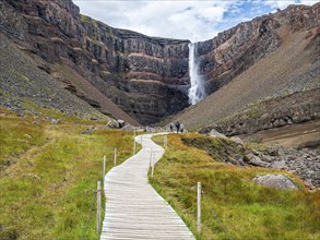 Waterfall Hengifoss, basaltic layers interwoven with red sedimentary layers, wooden boardwalk for