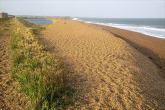 North Sea coastline view of shingle ridge and lagoon on beach bar, Shingle Street, East Lane,