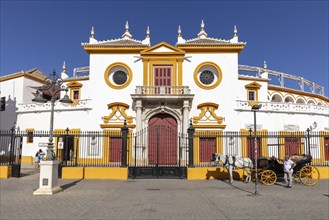 Facade of the Spanish-style bullring with carriage in the foreground, Seville