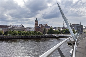 View over a bridge with a church in the background and dense cloud cover, Londonderry