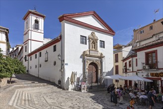 White church with bell tower in a sunny old town, Granada