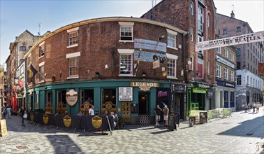 Historic corner building in a busy street with references to Beatles history, Liverpool