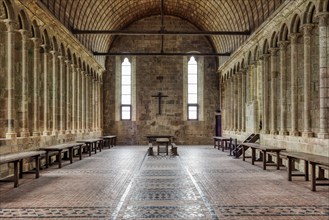 A quiet monastery room with stone arches, tables and high windows, Le Mont-Saint-Michel