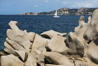 Bizarre granite rocks and sailing ship, Spiaggia del Faraglione, Palau, Costa Smeralda, Sardinia,