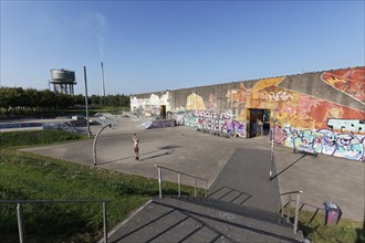 Rheinpark Duisburg, skate park with graffiti wall, single man throwing in the basketball hoop,