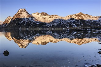 Fjord with steep snowy mountains, evening light, reflection, Flakstadoya, Lofoten, Norway, Europe