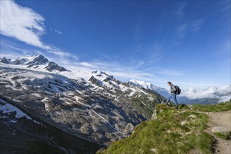 Mountaineer on a hiking trail, view of high alpine mountain landscape, summit of Aiguille de