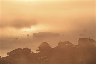 Inuit settlement in front of icebergs in the fog, midnight sun, summer, Ilulissat, Ilulissat