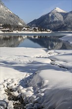 Mountains reflected in lake, village, houses, winter, snow, sunny, Walchensee, behind Jochberg,