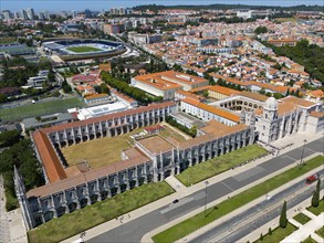 Aerial view of a large monastery in an urban landscape with green areas and urban structures in the