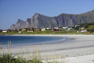 Village off Bergen with colourful houses on a white sandy beach on a sunny day, blue water,