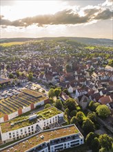 Urban scene at sunset with numerous rooftops, a central church and the surrounding hills, Weil der