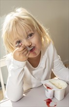 Portrait of blonde girl, 3 years old, having lunch in Ystad, Skåne County, Sweden, Scandinavia,