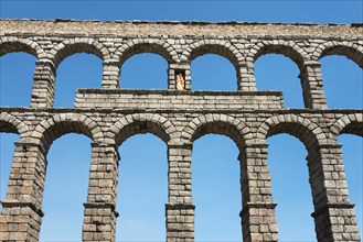 Ancient stone aqueduct with several arches in front of a blue sky, Aqueduct, Segovia, Castilla y