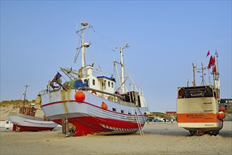 Fishing boats on a sunny day on a sandy beach under a blue sky at the North Sea, Lokken, Jutland,