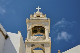 Close-up of a church tower with cross and bells under a bright blue sky, Platia and church Issodia