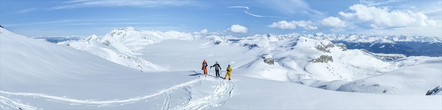 Three ski tourers in front of a snow-covered glacier plain, Plaine Morte Glacier, Bernese Alps,