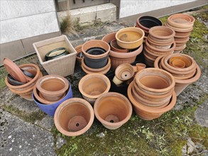 Used clay flower pots, red, stacked on the ground, various sizes, horticulture