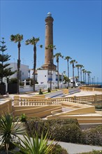 Promenade with palm trees and lighthouse on a sunny day, Faro de Chipiona, Chipiona, Cádiz