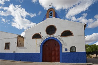 A white and blue church with a bell tower under a cloudy sky, Ermita de San Pedro, Campo de