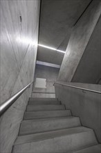 Small concrete staircase in a modern and minimalist interior with lighting, University of