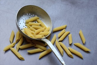 Pasta, Italian penne in a sieve ladle