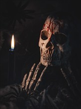 A bloodstained skull with candlelight in a dark and eerie atmosphere