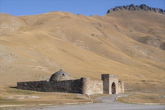 Historic caravanserai Tash Rabat from the 15th century, with yellow hills, Atbashy district in the