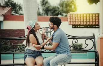 Man arguing with girlfriend sitting in a park. Young couple arguing sitting on a park bench,