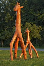 Giraffes made of red painted tree trunks, wooden sculpture by Günter Schumann, Museum of the