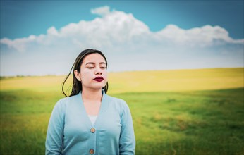 Relaxed girl breathing fresh air in the field. Close up of relaxed woman breathing fresh air in the