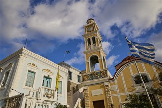 Paraklesio Church, Church tower next to yellow building, framed by heavenly scenery and a Greek