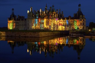 Chambord Castle with summer evening light show and moat, Chambord, Loir-et-Cher department, Centre