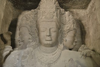 Figure of a three-headed Shiva in the main cave of the Shiva temple on Elephanta Island, UNESCO