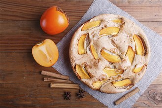 Sweet persimmon pie on brown wooden background. top view, copy space