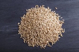 Heap of oats grains isolated on black background. close up, top view