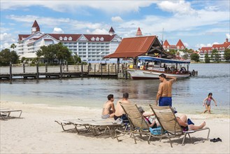 Disney's Polynesian Resort guests enjoy the beach overlooking the Grand Floridian Resort in Walt