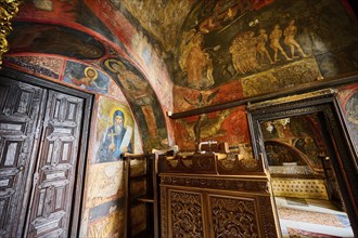 The scene shows an Orthodox icon and wall painting in a room with wooden doors and detailed