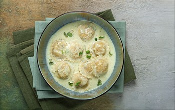 Ravioli in cream sauce, spices and herbs, top view, no people