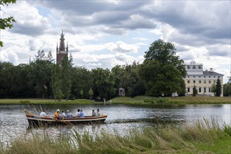 Gondola travelling past the castle and the Bible Tower in Wörlitz Park, Wörlitz, Saxony-Anhalt,