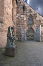 Main entrance of St Clare's Church, on the left the bronze sculpture of Job, created by the German