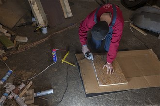 Young man working with an angle grinder in his workshop, Mecklenburg-Western Pomerania, Germany,