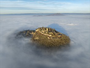 Aerial view of the Hegau volcano Hohentwiel with the upper fortress ruins illuminated by the rising