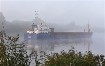 Cargo ship sailing in fog in the Kiel Canal, Kiel Canal, Schleswig-Holstein, Germany, Europe