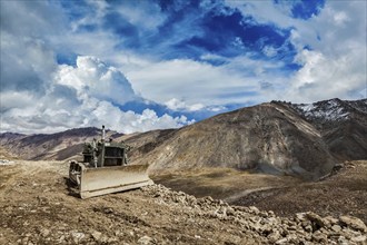 Bulldozer on road in Himalayas. Ladakh, Jammu and Kashmir, India, Asia