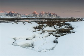 Winter landscape, mountain peaks in the sunset, Lofoten island Vestvågøya at the fjord